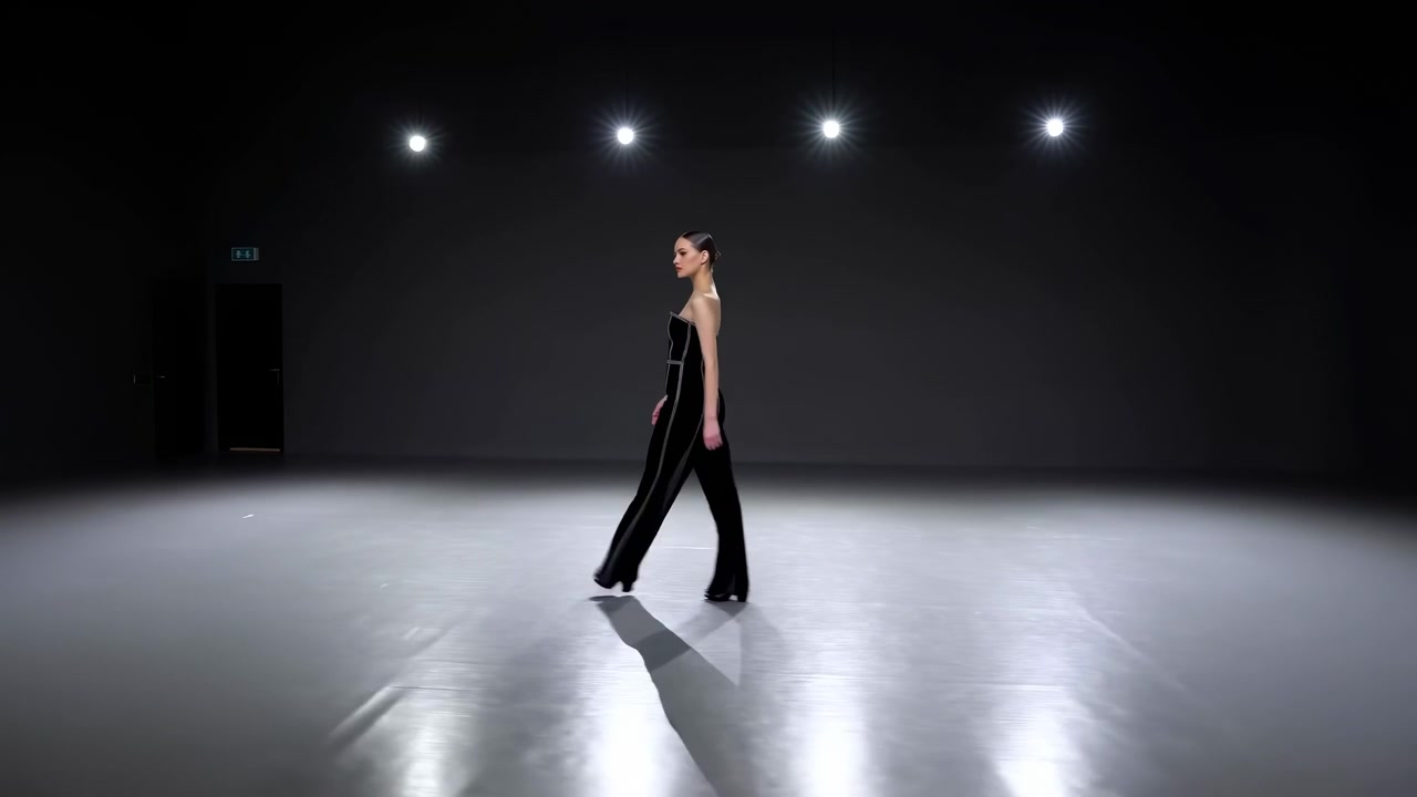 Solitary Caucasian Model Walks Under Spotlights Across Glossy Floor, Minimalist Studio Setting, Editorial
