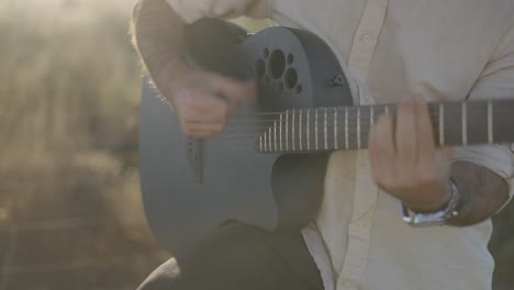 hombre tocando la guitarra acústica al aire libre