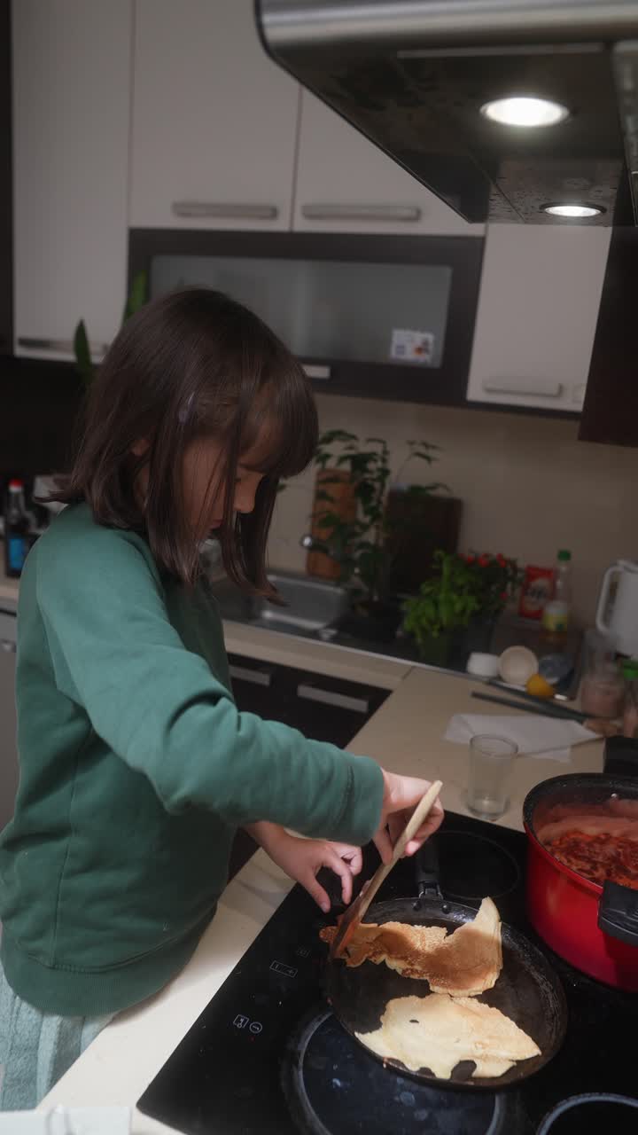 Ragazza che cucina i pancake in cucina