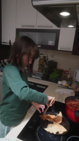 girl cooking pancakes in the kitchen