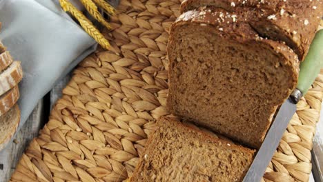 sliced bread loaf with wheat grains and knife