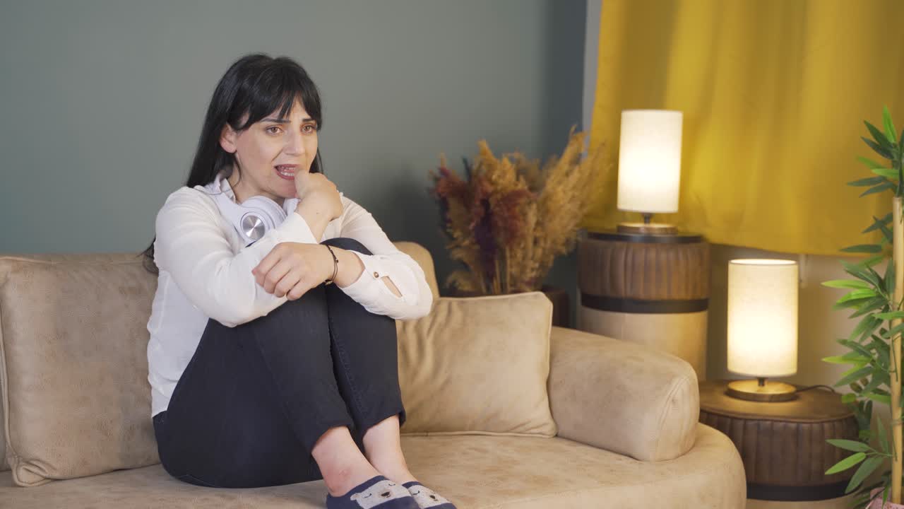 밤에 혼자 집에 있는 여자, 겁에 질려 주위를 둘러보고 있습니다.