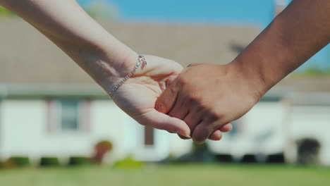 a young couple holding hands against the backdrop of their new home buying real estate concept a dre