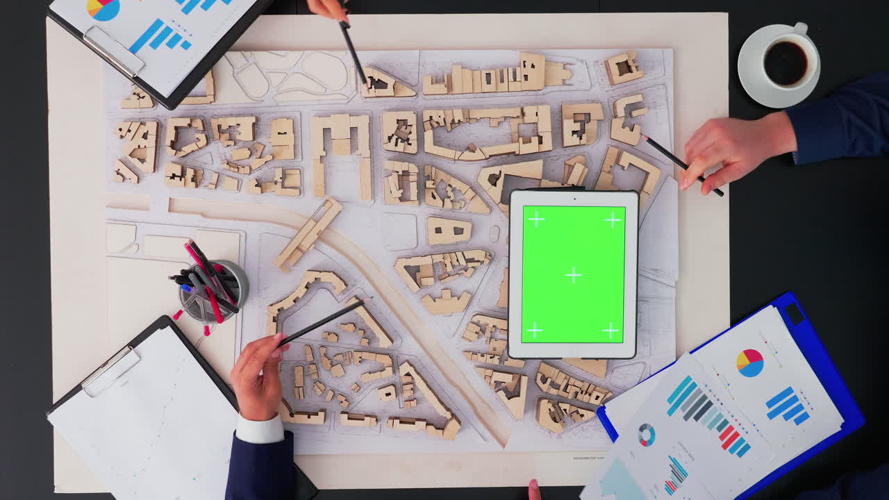 arquitectos trabajando con prototipo de ciudad y tableta de pantalla verde