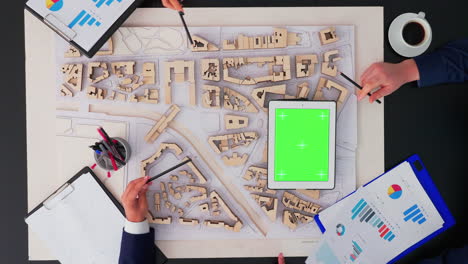 Arquitectos-Trabajando-Con-Prototipo-De-Ciudad-Y-Tableta-De-Pantalla-Verde.