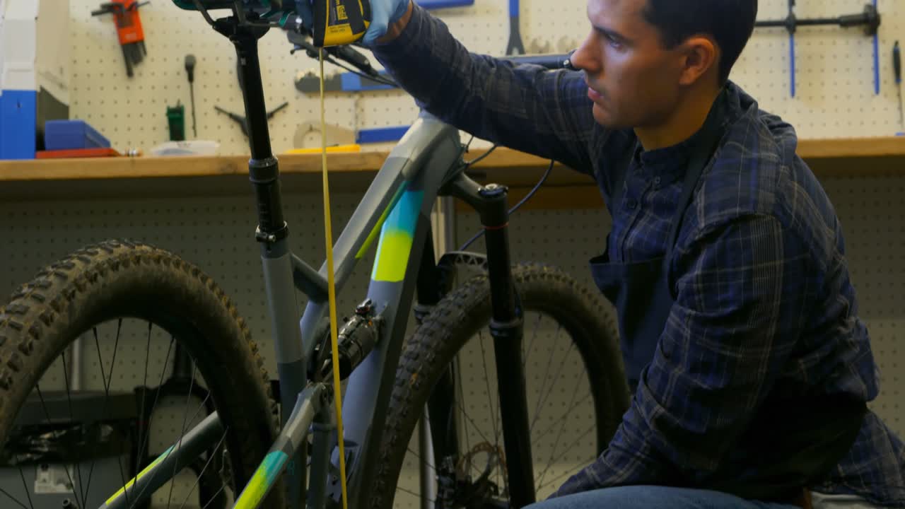 hombre reparando una bicicleta en el taller 4k