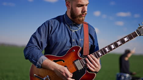 Man Playing Electric Guitar in a Field