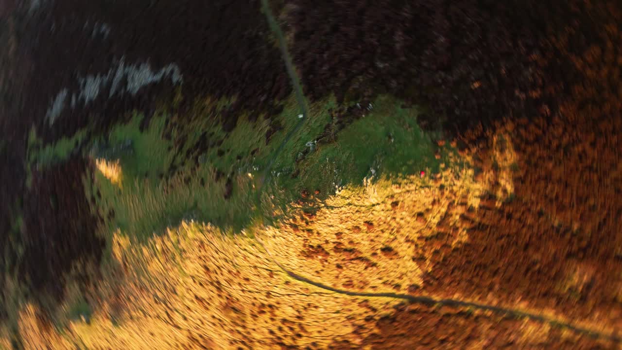 Rapidly Spinning Abstact Aerial Footage of Light and Dark Shadows in Sunset Light with Winding Coast Path and Sunlit Hillside on Coastal Path. Drone Footage 4K.