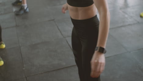 a strong and athletic young female doing squats in the gym during a class