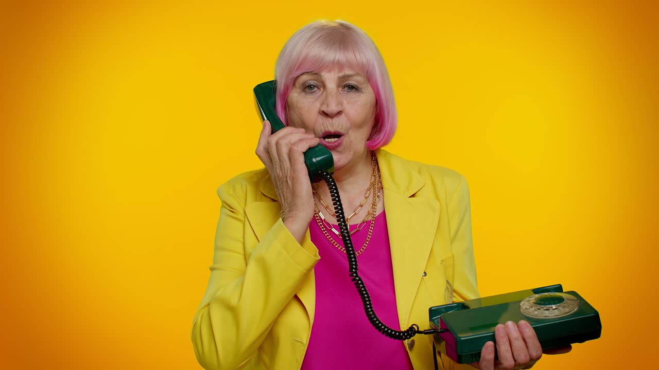 "80년대의 고대 드 전화로 대화를 나누는 고급 스타일의 할머니가 ""이봐요, 전화해 주세요."""