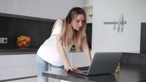 Mujer-Que-Pasa-Tiempo-Con-Una-Laptop-Usando-Audífonos-En-Casa