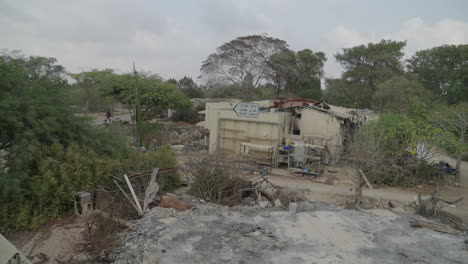 on top of destroyed home in kibbutz nir oz after hamas attack, gush katif sign
