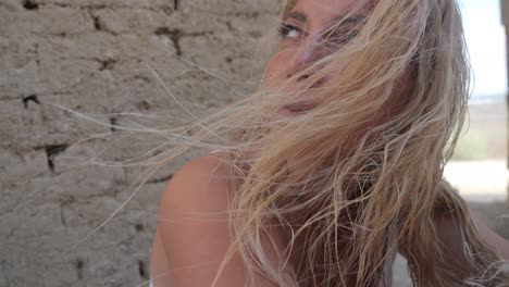 woman in a white dress near ruins close-up with the wind blowing in her hair