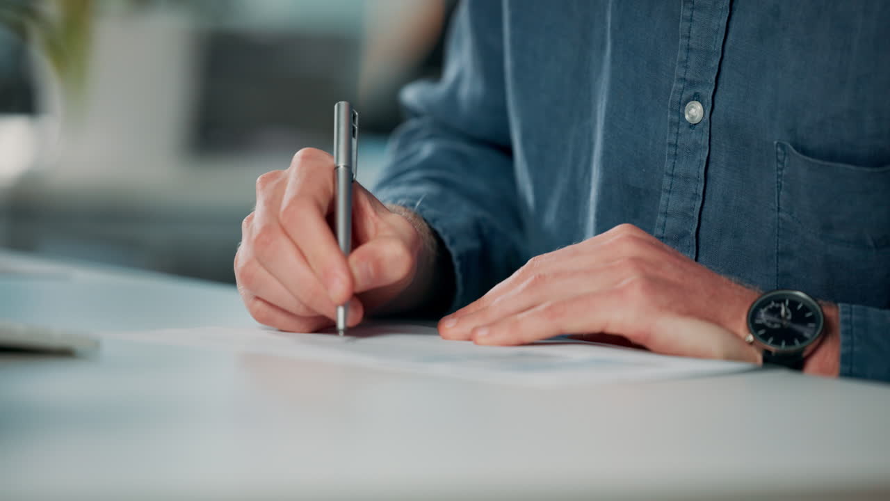 Man writing on paper at desk