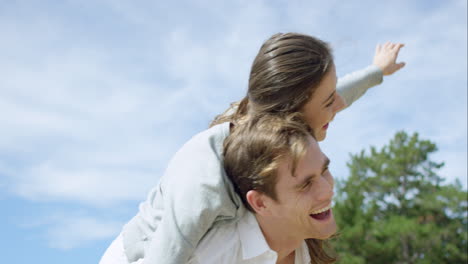 pareja feliz disfrutando al aire libre sonriendo brazos extendidos girando en cámara lenta en el dragón épico rojo