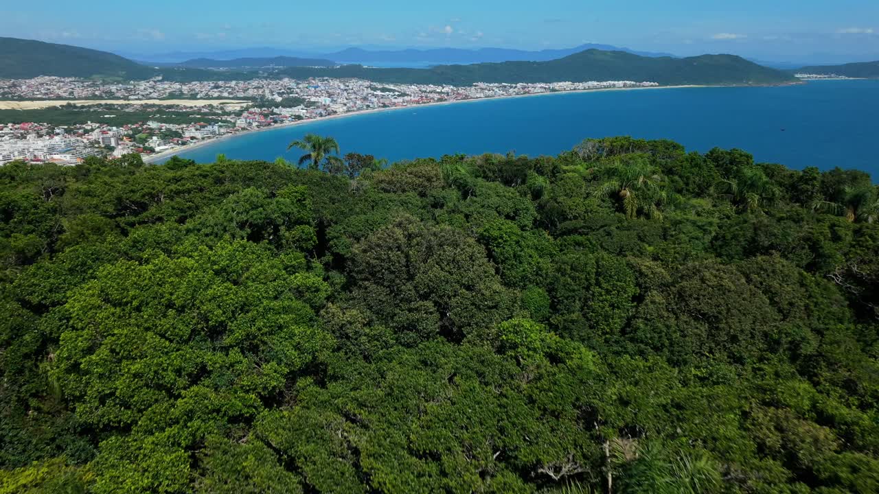 Pemandangan udara menakjubkan dari titik pandang Santinho di lereng bukit ke pantai populer Praia Dos Ingleses, Florianopolis, Santa Catarina, Brasil.