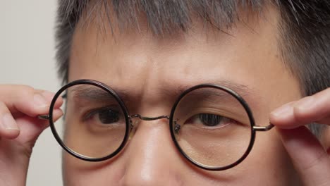 close up young southeast asian man's eyes portrait, try on eyeglasses, glasses