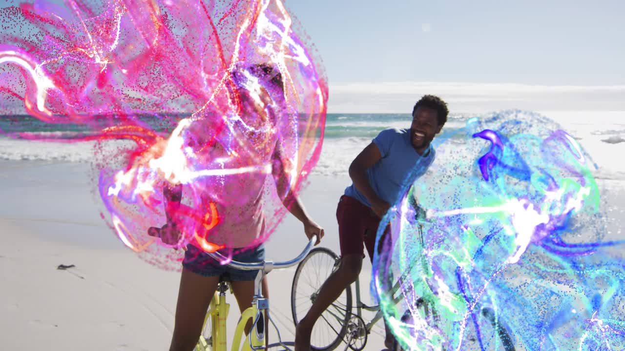 Couple riding bikes on beach, orbs coming from sides and sweeping over riders merging for marketing
