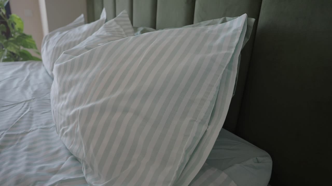 Close-up of pillows on a bed with striped bedding