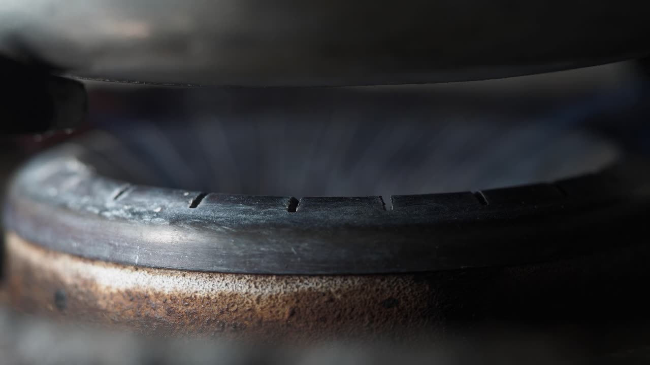 primer plano de un quemador de estufa de gas con una olla en la parte superior