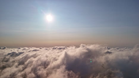 Sky view above the clouds with the sun shining through a bright, serene atmosphere