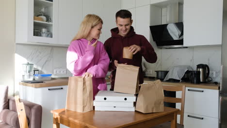 pareja con paquetes en su cocina