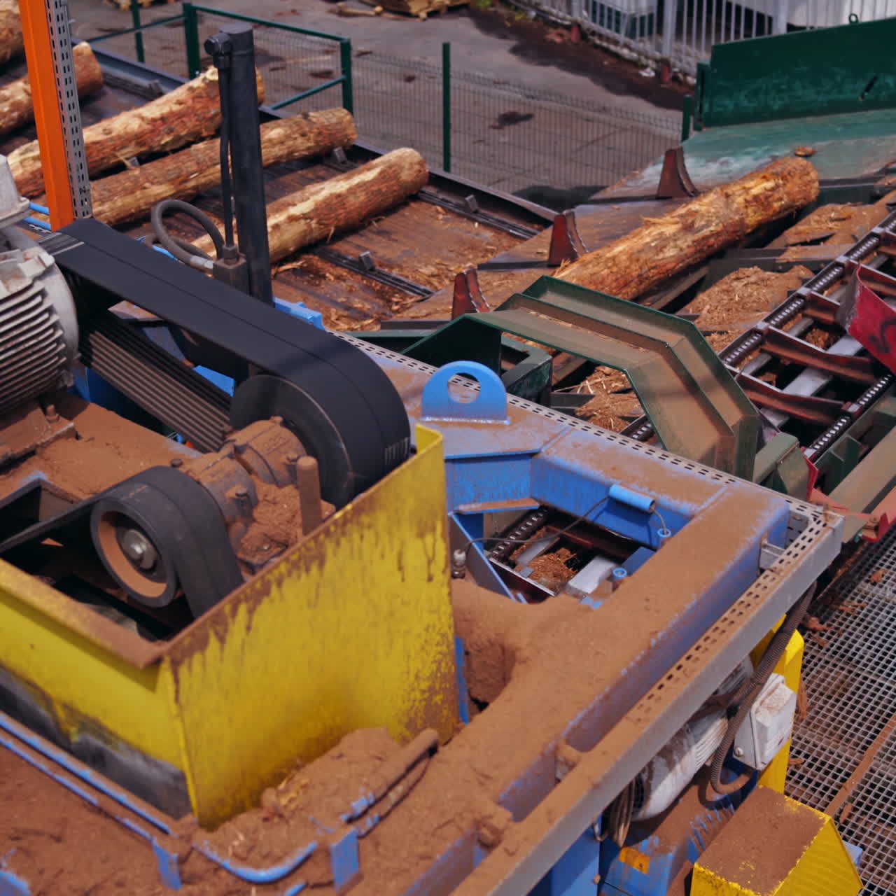 Sawmill. Process of removing bark from logs. Special machinery with conveyor. heavy technic at plant, logging industry. View from the top.