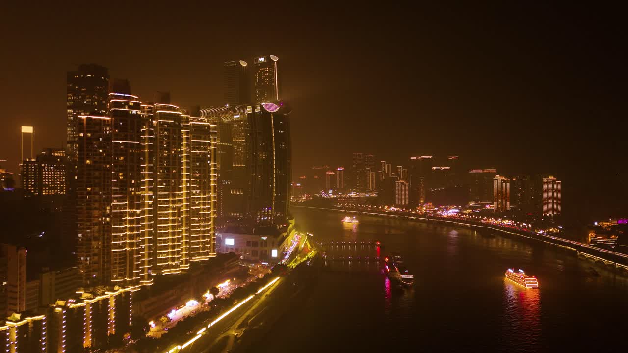 Pull out drone shot of Chongqing cityscape at night with Yangtze River in Yuzhong District, China