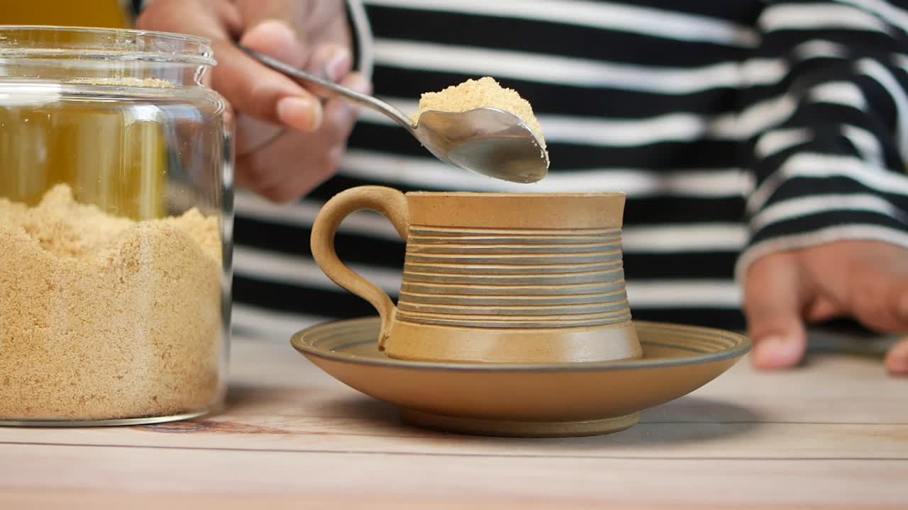 añadir azúcar marrón a una taza de café o té