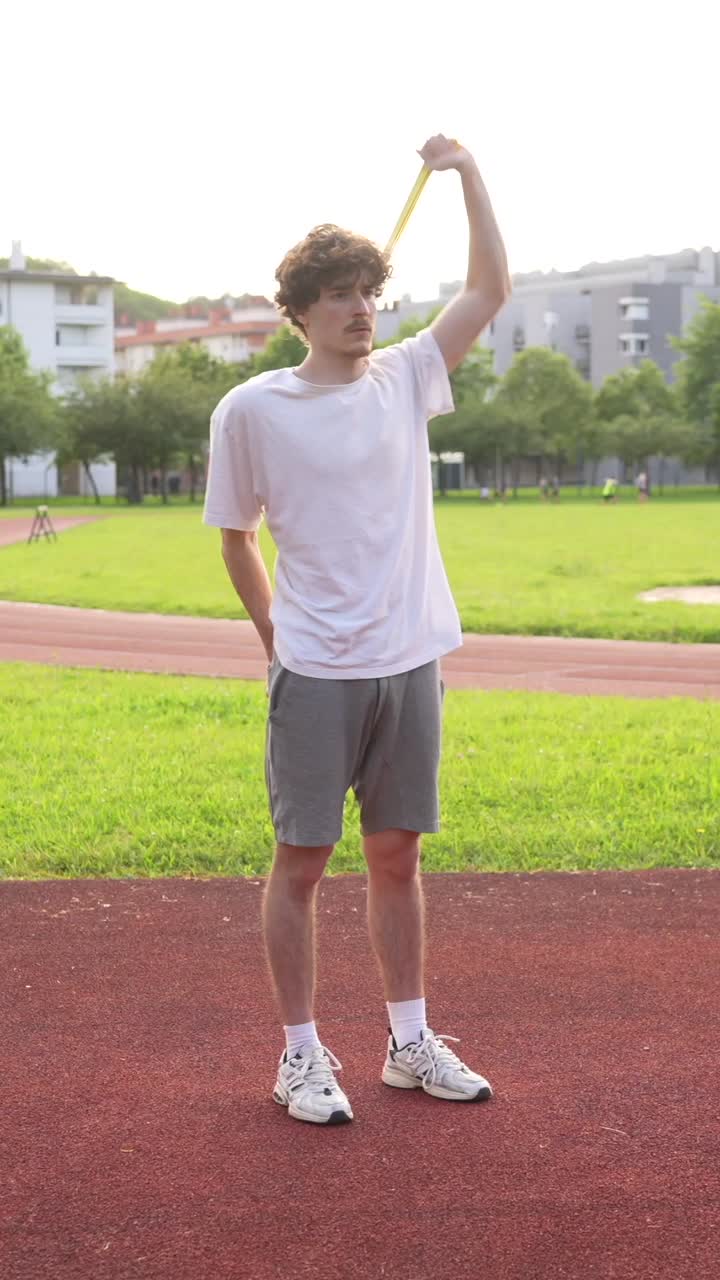 Man exercising with a band on a running track