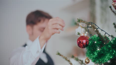 Guapo-Colgando-Chuchería-Roja-En-El-árbol-De-Navidad-Iluminado