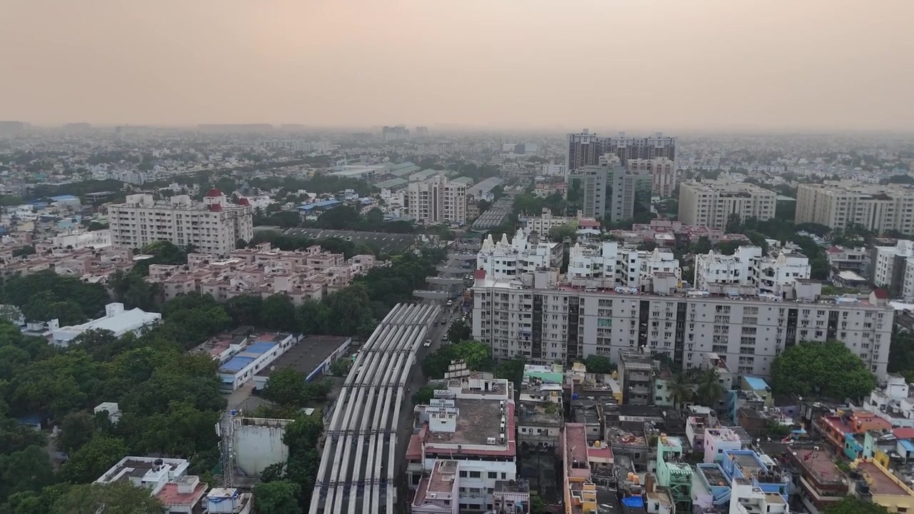 Una vista a volo d'uccello dell'estesa area di Koyembedu a Chennai, che mostra il massiccio terminal degli autobus e lo skyline in crescita della città.