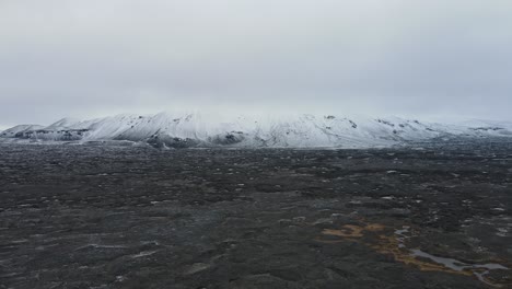 Big mountain covered with snow in front of a bib lava field
