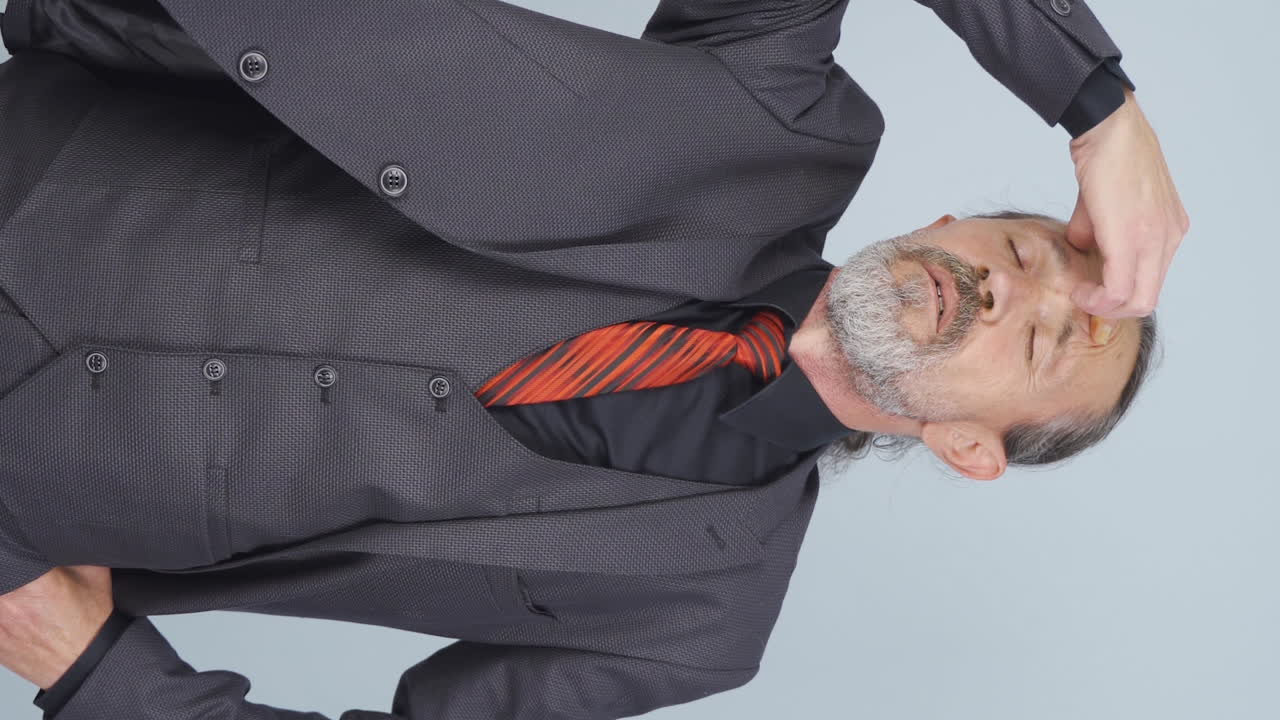 Vertical video of Old businessman with migraine.