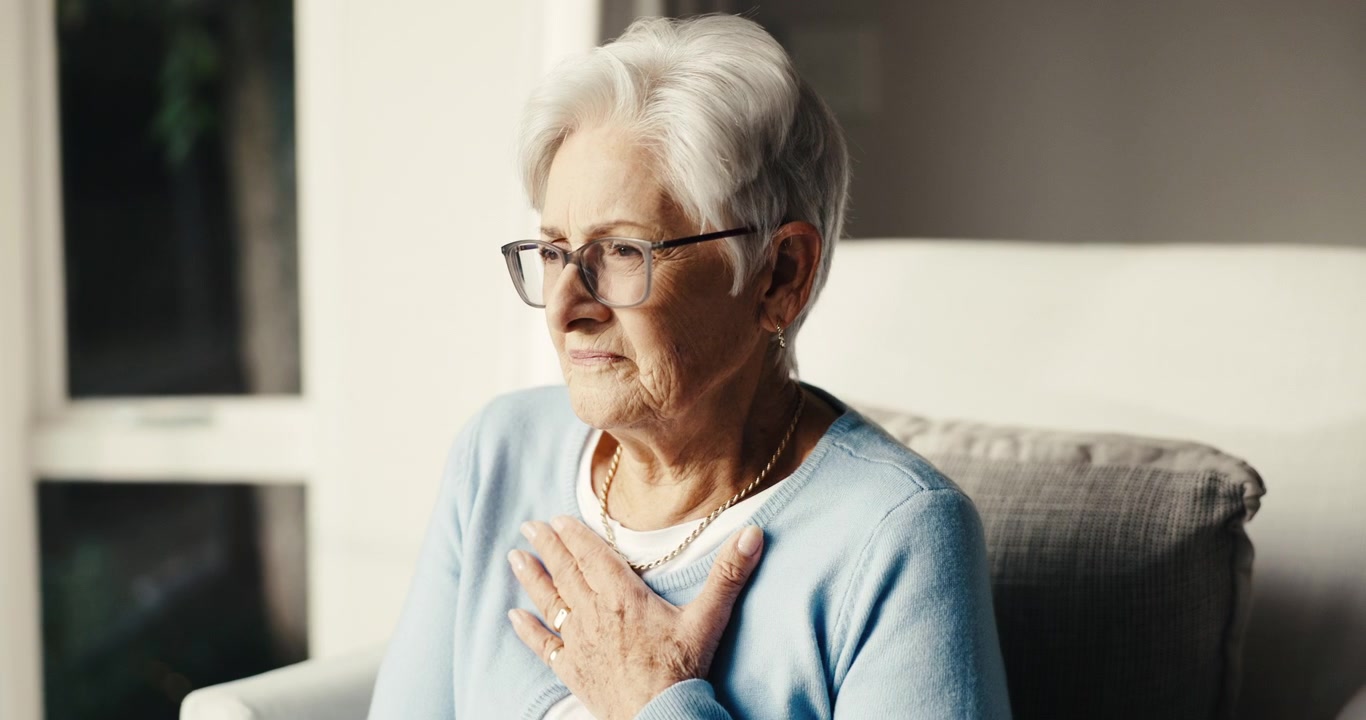 Elderly Woman Coughing and Holding Her Chest at Home