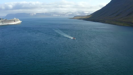 tender-boat taking passengers from cruise ship to a port in iceland - isafjordur port