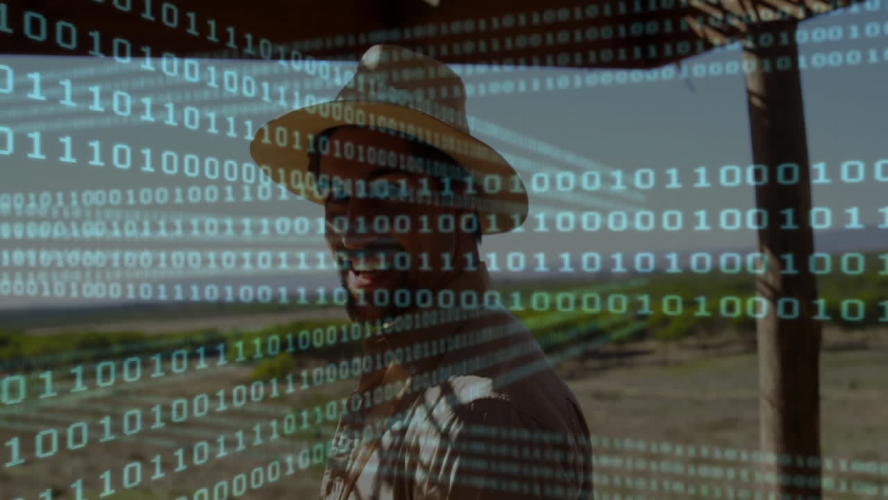 Man wearing straw hat standing in farmland, with green binary code overlay showing farm tech data