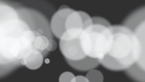 grandes partículas blancas y bokeh redondo sobre fondo negro