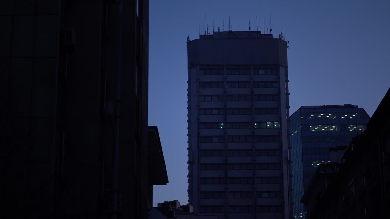 vista de la hora azul de oficinas altas y edificios de apartamentos con pocas luces encendidas
