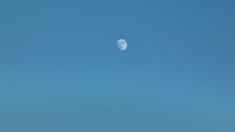 waxing gibbous moon against blue sky time lapse