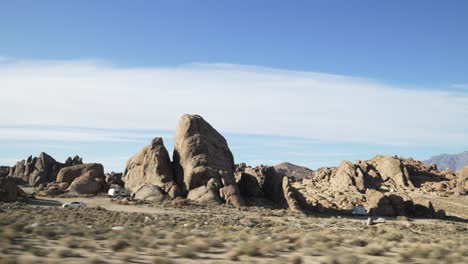 view from a moving car that is driving in desert with mountains in alabama hills on american road trip