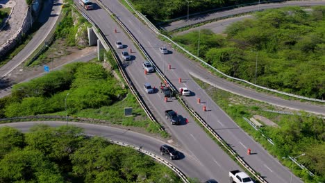 drone empujar en la inclinación hacia abajo a la zona de cones como trabajadores reemplazar y reparar la barrera mediana de metal