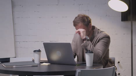 stressed businessman closing laptop computer and leaving the meeting room