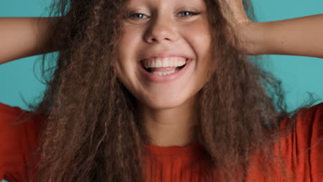 caucasian curly haired woman smiling to the camera.