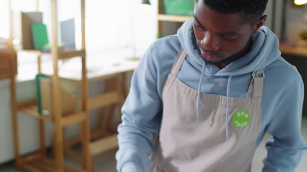 Black Man Putting Stickers on Containers with Healthy Food
