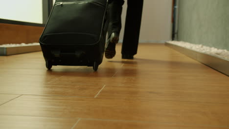person walking with a suitcase in a hotel lobby