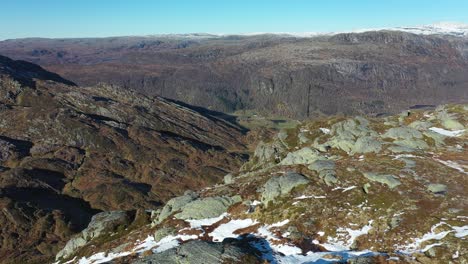 Aerial-flying-above-landscape-photographer-on-mountaintop-before-revealing-majestic-Nesheim-and-Eksingedalen-valley-in-Norway