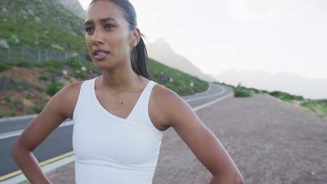 mujer afroamericana vestida con ropa deportiva tomando un descanso de correr en la carretera