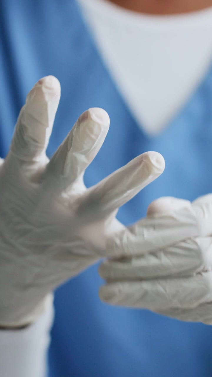 Healthcare Professional Putting On Sterile Medical Gloves