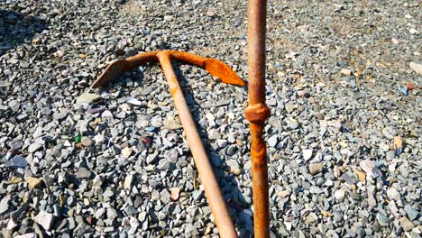 Weathered-old-iron-anchor-rusting-on-stone-shingle-beach